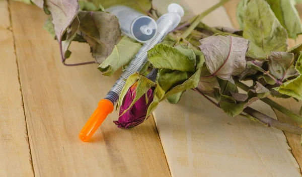 Dried rose and syringe — Stock Photo, Image