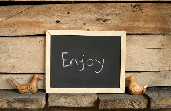 Blackboard schrijven op houten achtergrond — Stockfoto