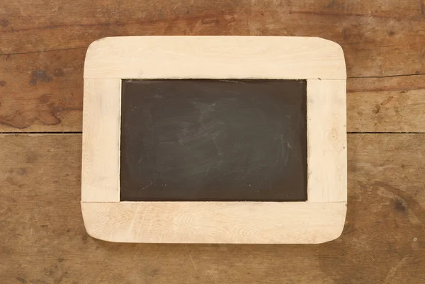 Blackboard on wooden background — Stock Photo, Image