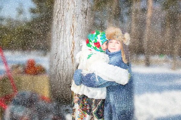 Children in Russian pavloposadskie scarf on head with floral print on snow.  Russian style on a background of samovar and with  bagels — Stock Photo, Image