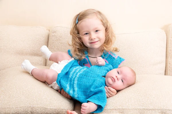 Két sisters. Nővére gyerek, átölelve a újszülött kis húga. Aranyos gyerekek lányok ágyon otthon. — Stock Fotó