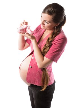 Bebek ayakkabısı tutan hamile kadın.