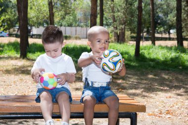 Little boys  with soccer ball in park clipart