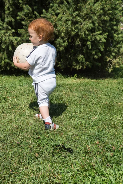 Lilla barn pojke med fotboll i parken — Stockfoto