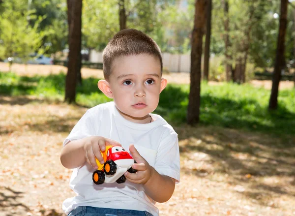 Little child boy plays with toy car — Stock Photo, Image