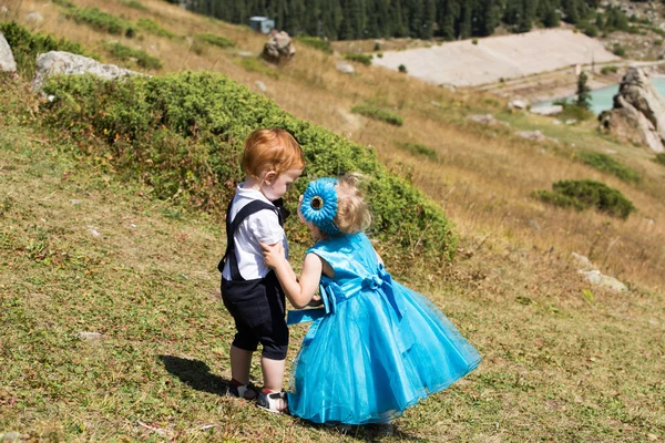 Bebê menino e criança menina beijando na grama . — Fotografia de Stock