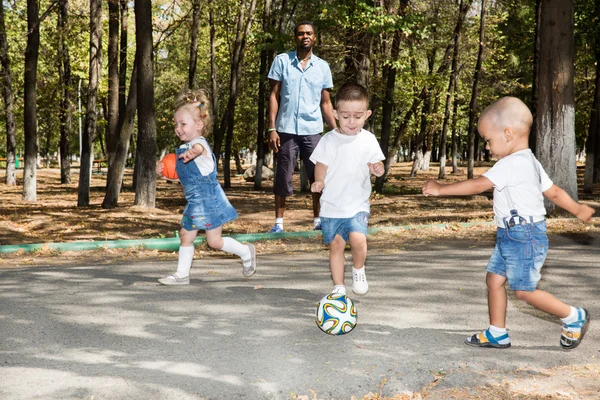 Děti si hrají s fotbalovým míčem — Stock fotografie