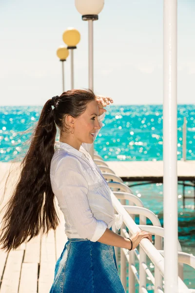 Mladá žena na molu u moře. — Stock fotografie
