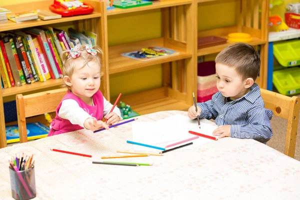 Due piccoli bambini che disegnano con matite colorate — Foto Stock