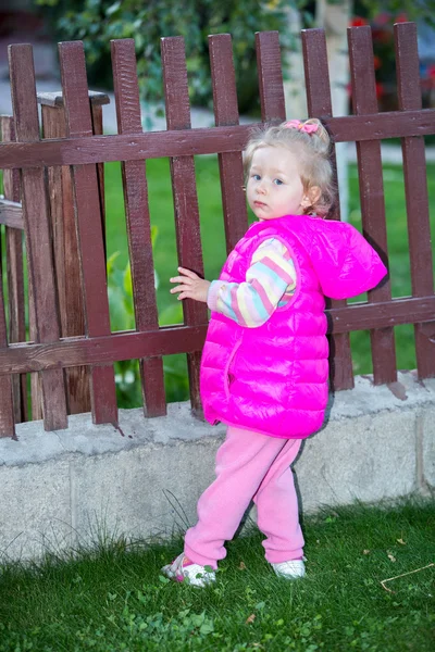 Child girl in park near fence — Stock Photo, Image