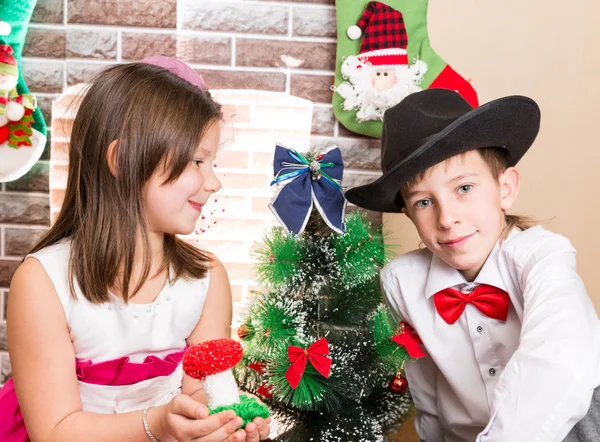 Boy gentleman and girl in ball dress by fireplace. Christmas and New Year — Stock Photo, Image