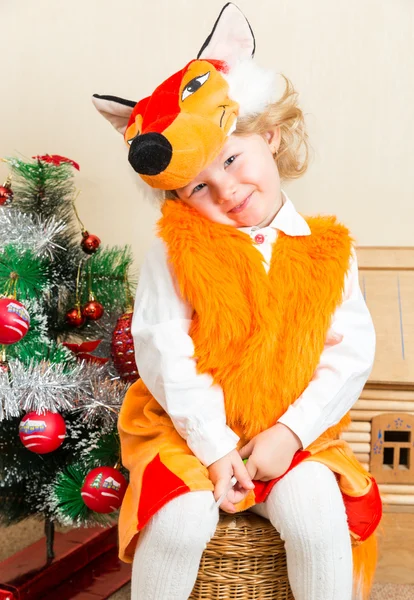 Kind meisje gekleed in fox pak in de buurt van de kerstboom. Het concept van Nieuwjaar en vakantie — Stockfoto