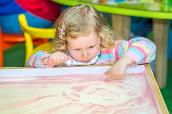 Niedliches Mädchen zeichnet auf Sand — Stockfoto