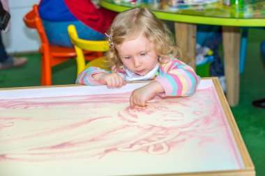Çizim kız şirin çocuk gelişmekte olan kum okul öncesi anaokulu tabloda de Montessori yöntemi tarafından çizer