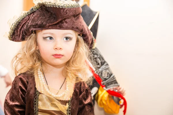 Niña niña vestida de pirata para Halloween en el fondo del árbol de Navidad. Niño con disfraces de carnaval para Navidad —  Fotos de Stock