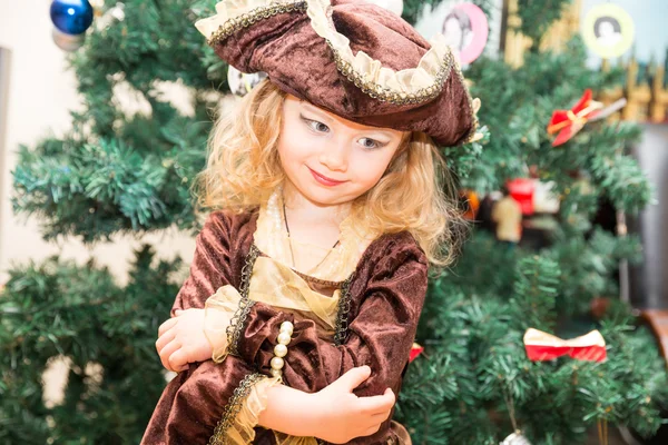 Niña niña vestida de pirata para Halloween en el fondo del árbol de Navidad. Niño con disfraces de carnaval para Navidad —  Fotos de Stock