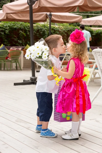 Çocuk çocuk kız çocuk için doğum gününde çiçek verir. Küçük sevimli kız 3 yıl doğum günü kutluyor. Çocukluk. — Stok fotoğraf