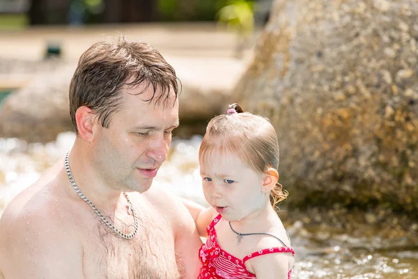 Active father teaching his toddler daughter to swim in pool on tropical resort. Summer vacations and sport  concept — Stock Photo, Image