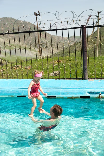 Active father teaching his child girl to swim in pool . Summer vacations and sport concept — Stock Photo, Image