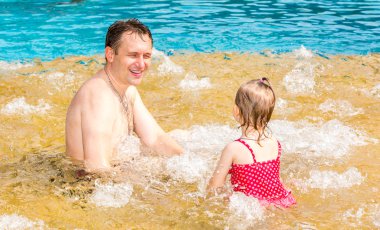Tropikal tatil Havuzda yüzmek için yürümeye başlayan çocuk kızı öğretim etkin baba. Yaz tatillerini ve spor kavram