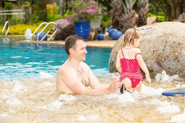 Active father teaching his toddler daughter to swim in pool on tropical resort. Summer vacations and sport  concept — Stock Photo, Image