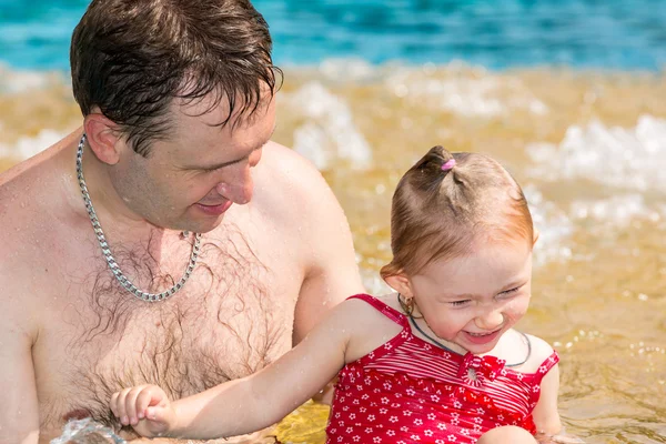 Ein aktiver Vater bringt seiner kleinen Tochter das Schwimmen im Pool eines Tropenbades bei. Sommerurlaub und Sportkonzept — Stockfoto