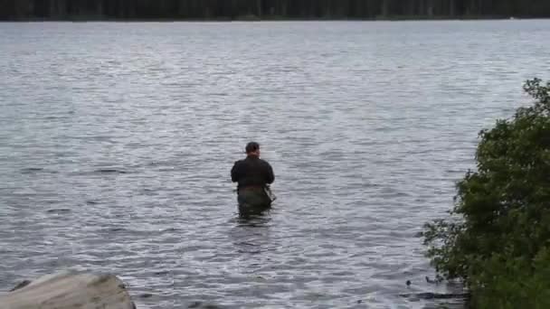 Hombre pescando en el lago — Vídeos de Stock