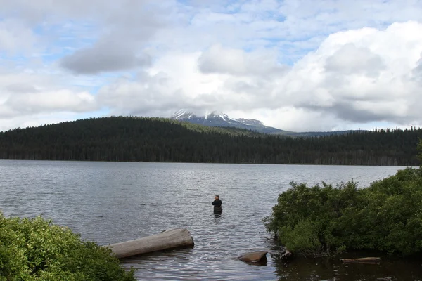 Homem pesca em um lago — Fotografia de Stock