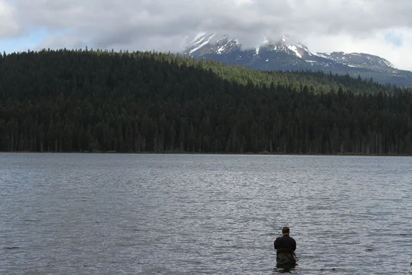 Uomo pesca in un lago — Foto Stock