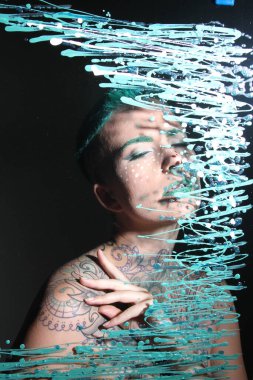 Camın arkasındaki bir modelin fotoğrafı.