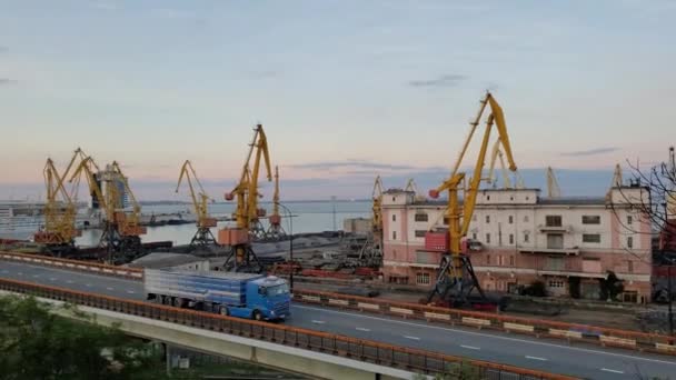 Industrielle Hafenlandschaft mit Frachtkränen und Lastwagenverkehr durch Überführung. 4K-Zeitraffer — Stockvideo