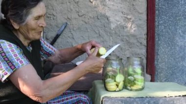 Yaşlı kadın kabağı dilimleyip kavanoza koydu.