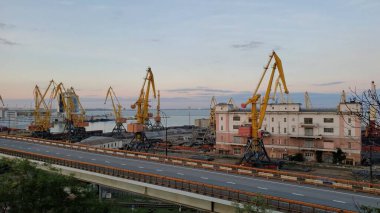 Liman kargo terminalleri ve yelkenleri açık sarı yükleyici vinçler. Boş üstgeçit yolu. Avrupa Karadeniz kıyısının limanındaki deniz manzarası. Odessa, Ukrayna, 10 20 2020