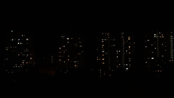 Ночное затихание света в окнах многоэтажных зданий в темноте — стоковое видео