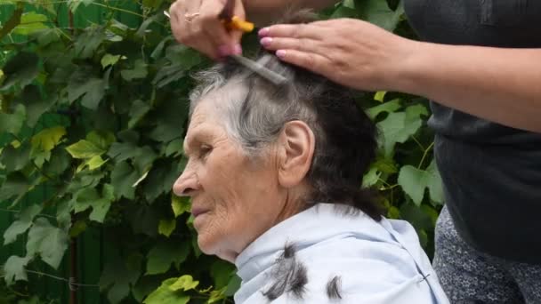 Обрізання волосся старшої жінки під час перебування вдома на карантині — стокове відео