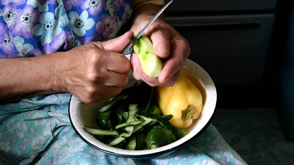 Зморщені Руки Річної Жінки Очищають Зелену Шкірку Від Сирого Огірка — стокове фото