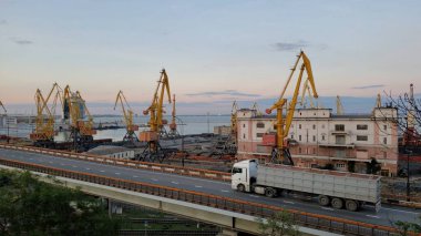 Liman kargo terminalleri ve sarı yükleyici vinçler. Yükseltilmiş yoldan geçen konteynır aracı römorku. Avrupa 'nın Karadeniz kıyısındaki liman arazisi ticareti. Odessa, Ukrayna, 10 20 2020