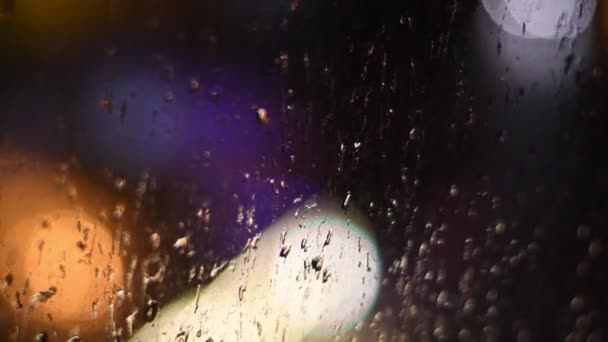 Borrão gotas de chuva noturna na janela suja com bokeh luzes de fundo — Vídeo de Stock