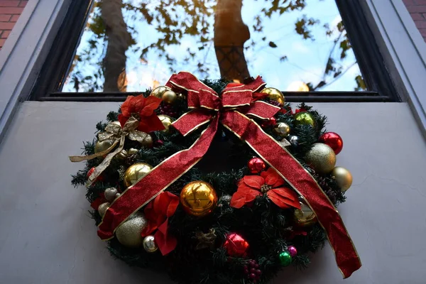 Grinalda de Natal tradicional sob a janela com reflexão borrão — Fotografia de Stock