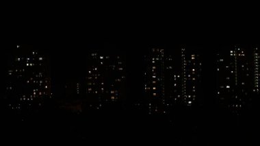 Karanlıkta çok katlı binaların pencerelerinde gece ışıkları