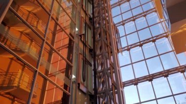 Günbatımında şirket binasında modern asansör aşağı yukarı hareket ediyor.