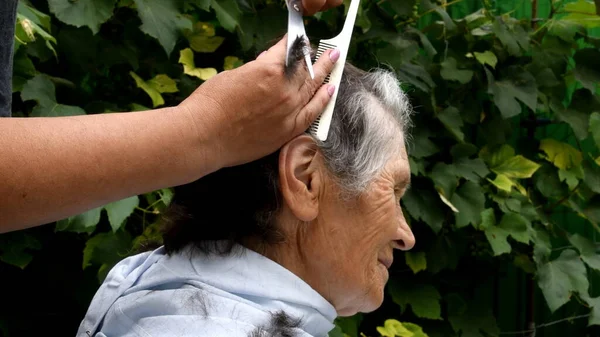 Cortando o cabelo da mulher sênior em casa enquanto quarentena — Fotografia de Stock
