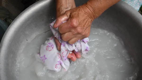 Lavagem à mão por mãos enrugadas de mulher velha — Fotografia de Stock