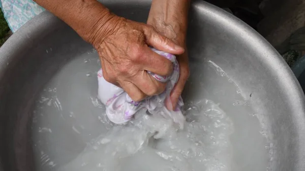 Handwash laundry by wrinkled hands of old woman — Stock Photo, Image