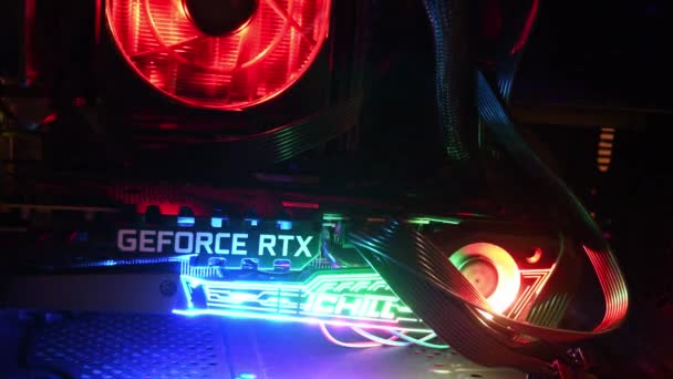 Крупный план NVidia GeForce RTX 3080 внутри игровой PC башни с красочными подсветками в темноте — стоковое видео