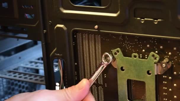 Male hand with metal wrench fix nut on bolt at computer motherboard — Stock Video