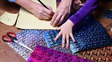 Anne ve çocuk hobi olarak parlak renkli kağıtlarla el sanatları yapıyor.