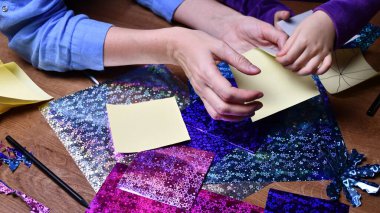 Anne ve çocuk hobi olarak parlak renkli kağıtlarla el sanatları yapıyor.