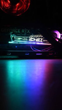 NVidia GeForce RTX 3080 oyun kulesinin içinde, karanlıkta yeşil-mavi arka ışıkları var.