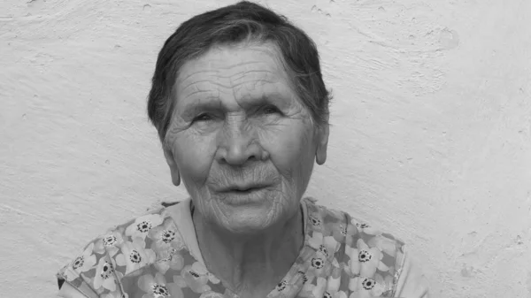 Monochrome portrait of concerned senior woman with short haircut and suspicious sight — Stock Photo, Image